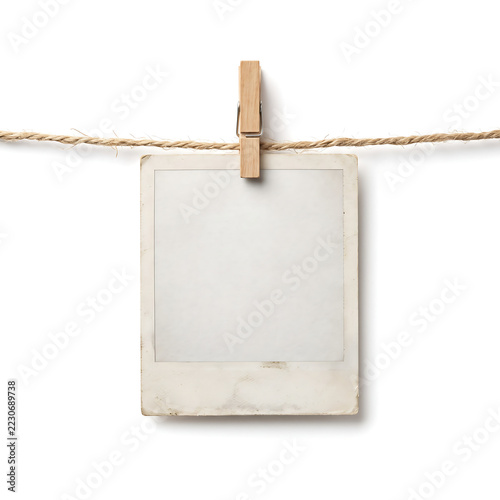 Blank vintage instant photo frame hanging on a rope with a wooden clothespin, isolated on a clean white background.