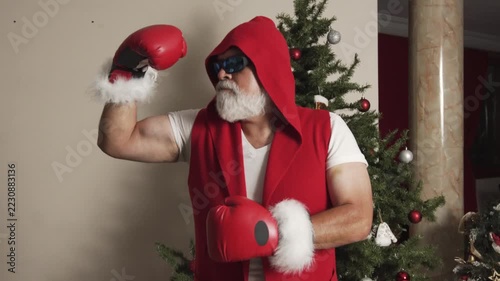 Boxer Santa throws punches beside Christmas tree