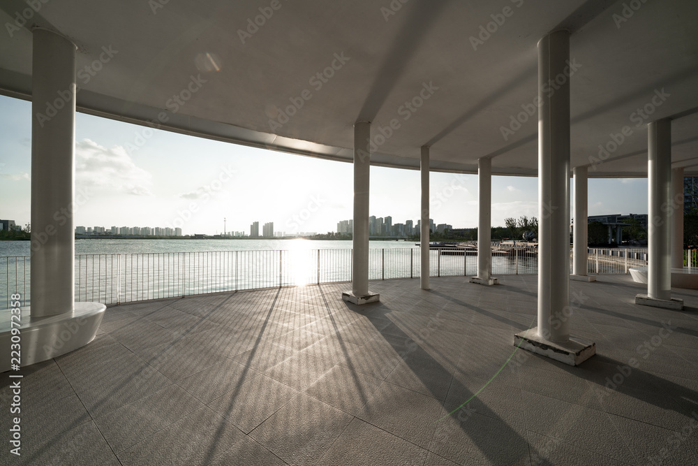 Obraz premium seaside colonnade building with white pillars and sunlight shadows