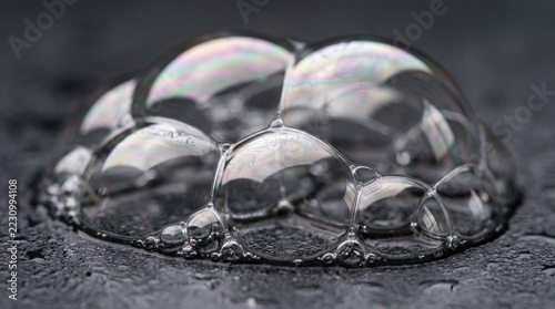 Iridescent Soap Bubbles With Pearlescent Reflections on Dark Textured Surface