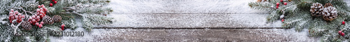 Christmas Banner of Snowy Fir Branches Cones and Red Berries on Wood with copy space