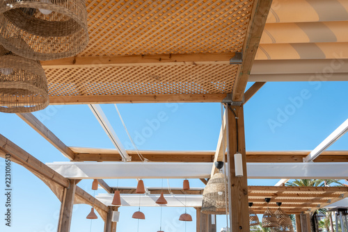 Pergola terrace with woven lamps and blue sky