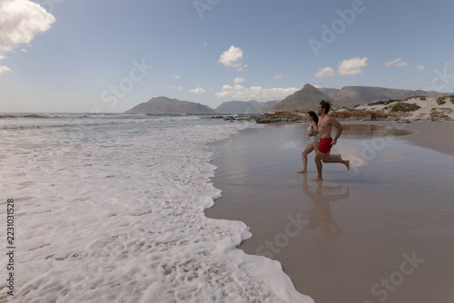 Young couple running and having fun at beach