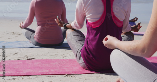Photography Diverse women practicing yoga on the beach