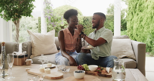 African American couple enjoying dessert together on patio, sharing joyful moment