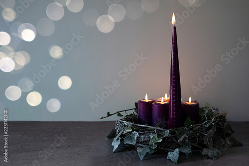 Hand lighting tall purple Advent candle, the traditional Christmas preparation.