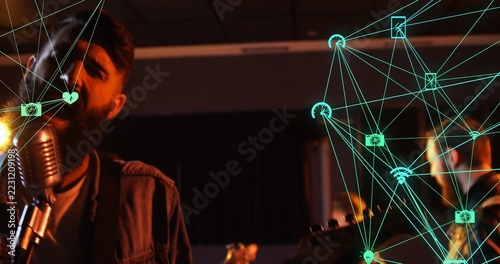 Singing bearded singer in denim jacket at stage by vintage mic, guitar, teal overlay, copy space