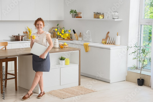 Remote work and work-life balance, young woman holding laptop and glass of ju...