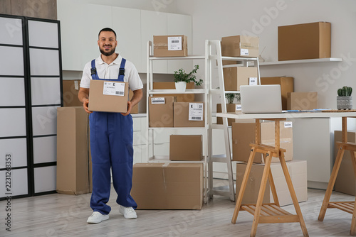 Logistics and delivery service, smiling courier holding cardboard box in home...