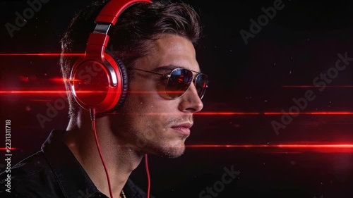 Man wearing red headphones and sunglasses faces right under red light lines in a dark studio
