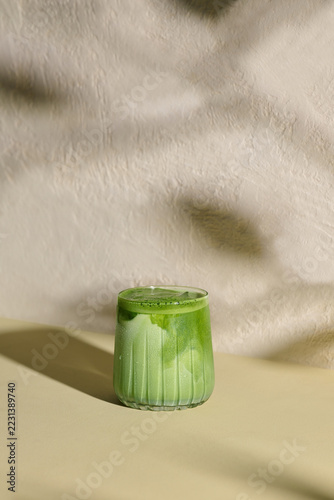 Refreshing Green Matcha Latte Served in Clear Glass on Beige Surface