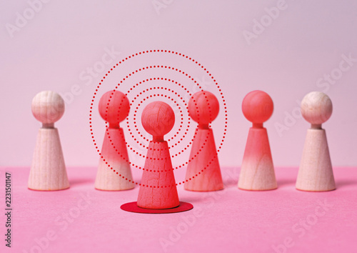 Contagion and Disease Transmission Concept with Wooden Figures on Pink Background