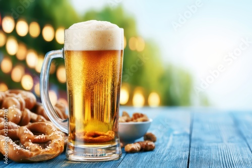 Golden beer in a clear mug at outdoor festival picnic table