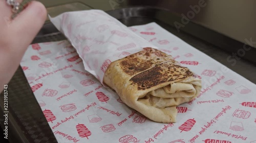 Hands wrapping a doner kebab for takeaway street food