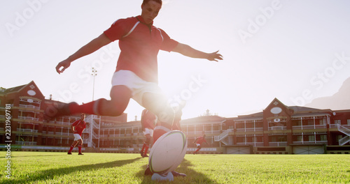 Low angle view of Caucasian rugby player kicking the ball from the kicking tee in the stadium