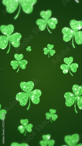 Vertical video: On start glitter clovers drifting down rotating decorating then opening looping