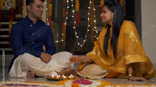 Diwali celebration - Indian brother and sister decorating and lightning diyas and teasing each other. 