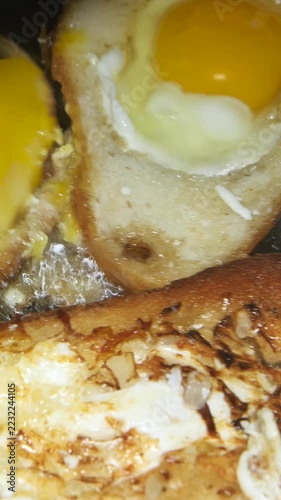 White bread with an egg frying in sunflower oil in a hot skillet, forming a crispy golden crust. Close-up footage of greasy comfort food and an indulgent, calorie-rich breakfast.


