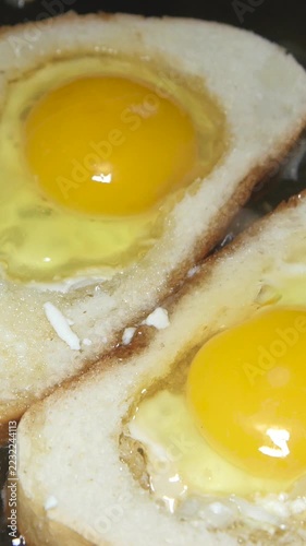 White toast and egg fry together in a generous layer of sunflower oil, creating a rich and oily breakfast. The footage emphasizes calorie-dense ingredients and indulgent eating habits.

