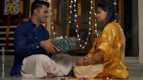 Diwali celebration at home - Brother giving a gift to sister  hug and kisses her . 