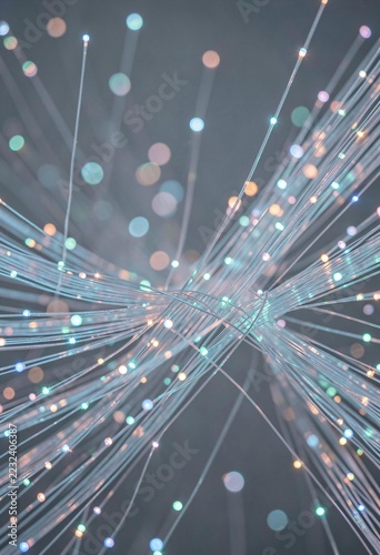 Macro view of glowing fiber optic cables transmitting data with colorful bokeh light effects in dark background
