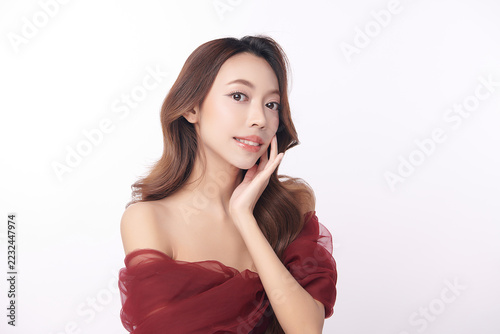 A beautiful young Asian woman with clean, fresh skin against a white background. Skincare, facial treatment, cosmetology, beauty, and spa. An elegant portrait of an Asian woman.