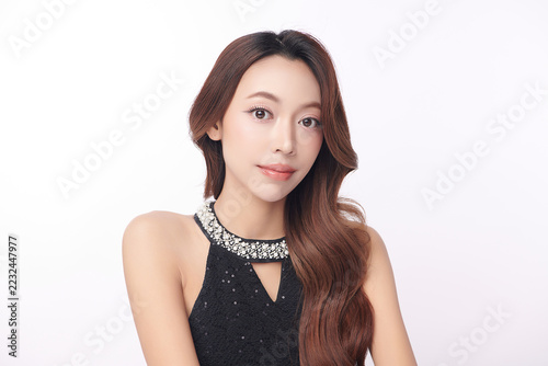 A beautiful young Asian woman with clean, fresh skin against a white background. Skincare, facial treatment, cosmetology, beauty, and spa. An elegant portrait of an Asian woman.