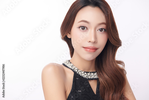 A beautiful young Asian woman with clean, fresh skin against a white background. Skincare, facial treatment, cosmetology, beauty, and spa. An elegant portrait of an Asian woman.