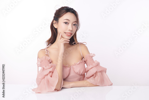 A beautiful young Asian woman with clean, fresh skin against a white background. Skincare, facial treatment, cosmetology, beauty, and spa. An elegant portrait of an Asian woman.