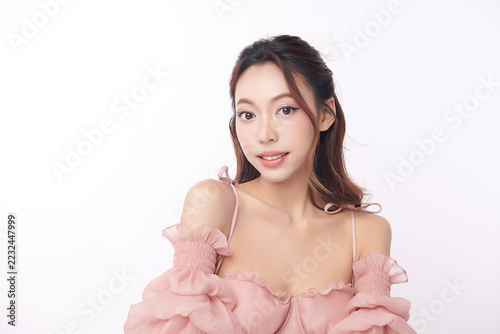 A beautiful young Asian woman with clean, fresh skin against a white background. Skincare, facial treatment, cosmetology, beauty, and spa. An elegant portrait of an Asian woman.