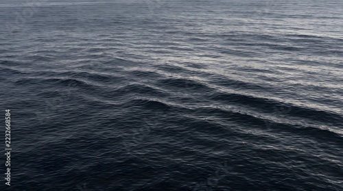 Close-up of dark blue water surface with gentle ripples and subtle light reflections