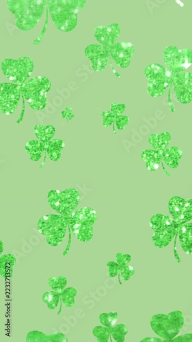 Vertical video: On play green shamrocks drifting down toward center with glints moving for ornament