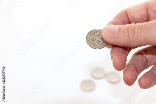 指でつまんだ硬貨