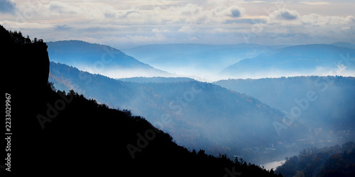 Elbe Sandstones - Czech Republic-Scenic panorama of misty mountain layers and rocky hills fading into the hazy distant horizon.