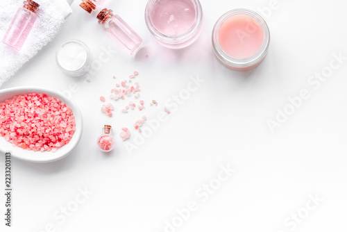 Spa products with rose oil. Cream, lotion and salt on white background top view copyspace