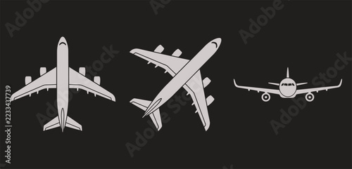 Gray airplane icon set on dark background, top view and front view jet aircraft silhouettes, flight symbols