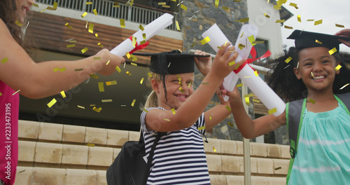Image of gold confetti over celebrating diverse schoolgirls with mortar boards and diplomas