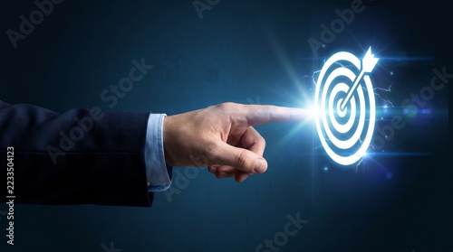 Businessman hand pointing glowing digital target with arrow in office
