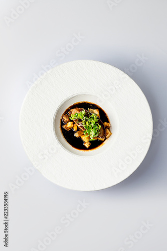 Fotografie Overhead foie gras with dark sauce and fruit in a textured wide rim plate