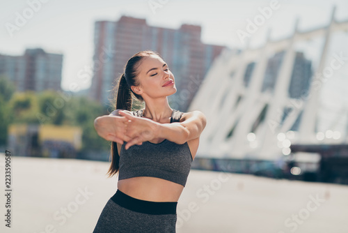 Photo of calm sporty lady trainer doing yoga exercise develop flexibility enjoy sun light outside gym