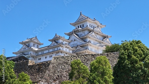 Historic Japanese temple architecture on a rocky hillside under a brig