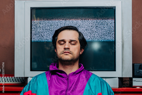 Relaxed retro man with eyes closed in front of static television screen