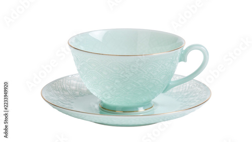 Photography Isolated elegant pastel mint green teacup and saucer set with delicate relief pattern and gold rim