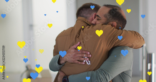 Image of heart icons over diverse gay couple embracing