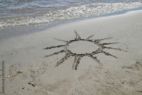 Soleil dessiné sur le sable d'une plage de Corse