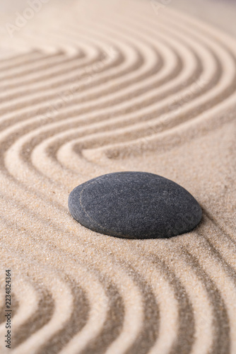 Zen stone on raked sand in a peaceful meditation garden
