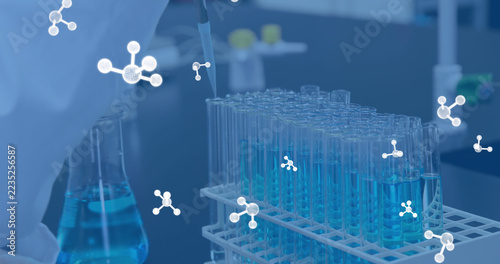 Image of molecules over caucasian scientist holding test tubes in lab