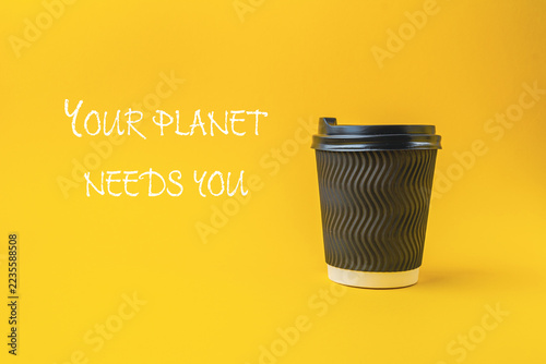Obraz na plátně A black eco friendly coffee cup with a wavy texture is placed against a bright yellow background