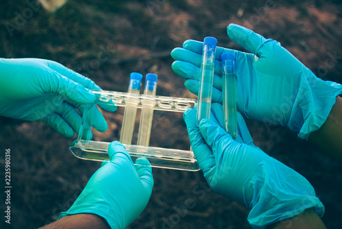Environmental inspection team gathering water samples from polluted sources for laboratory testing.