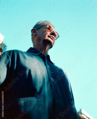 Photography Low-angle vintage portrait of a man in sunglasses against cyan sky